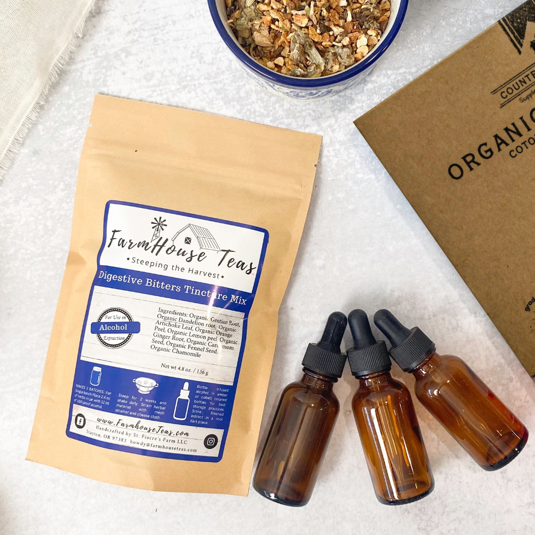 Digestive bitters tincture mix bag with three tincture bottles and corner of cheese cloth box with bowl of dried digestive bitters herbs.