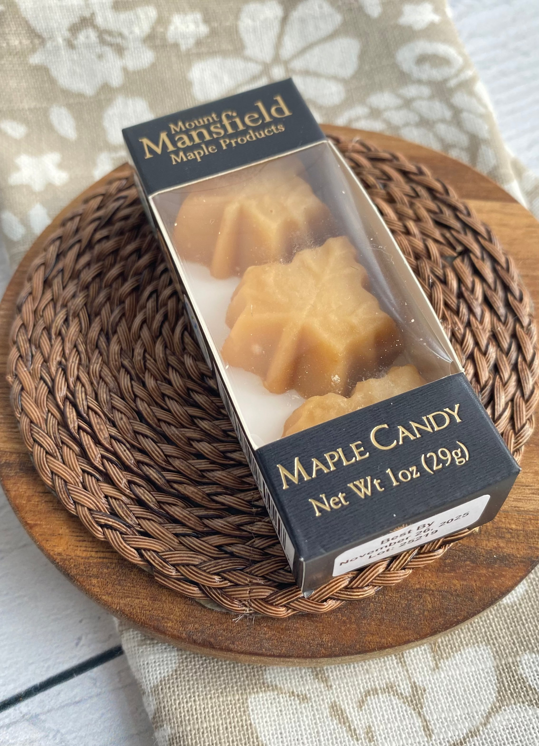 Box of Maple Candy on a wooden plate with a floral cloth background
