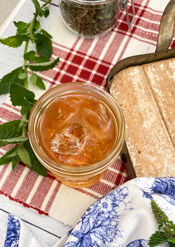 Jar of Mint Iced Tea on Checkered Cloth with fresh mint.