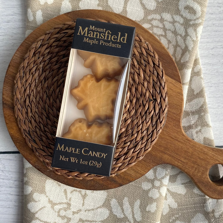 Wooden basket with a package of maple candies on a floral-patterned cloth