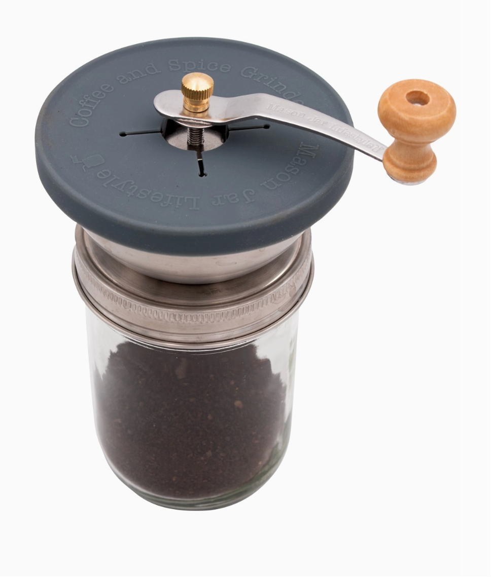 Two glass jars with manual coffee grinders on a white background