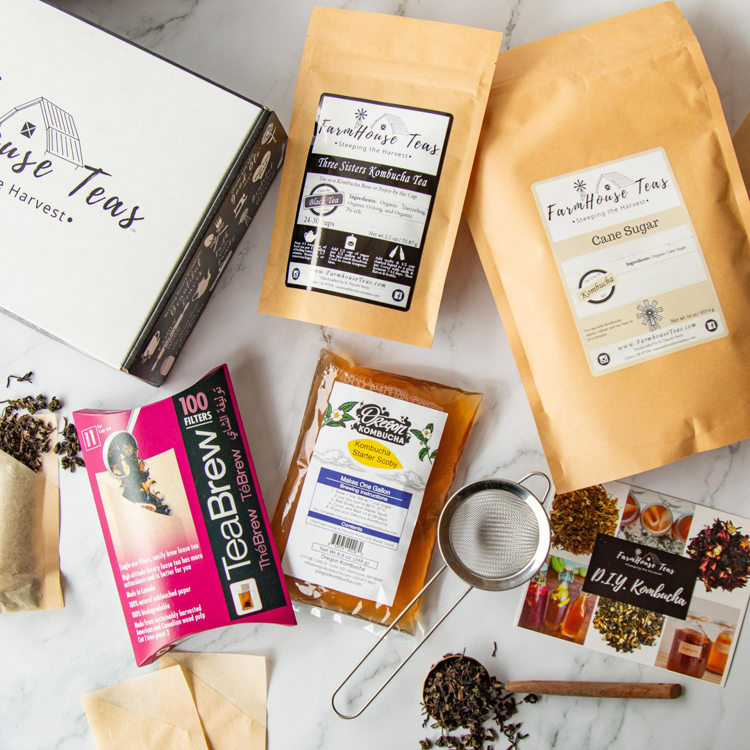 Tea packaging and accessories on a marble surface with 'FarmHouse Teas' branding.