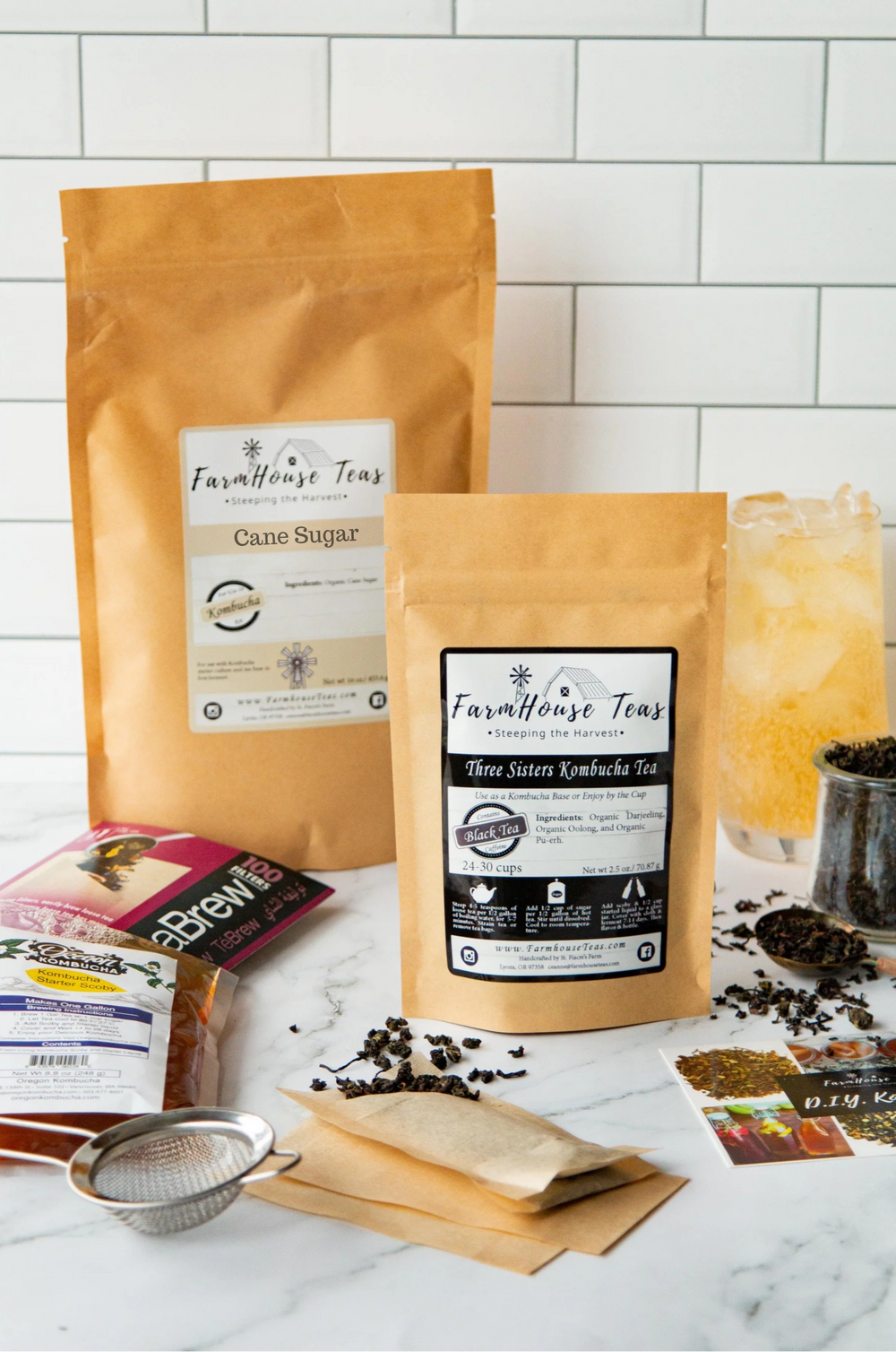 Two packages of Farmhouse Teas on a marble surface with a glass of iced tea.